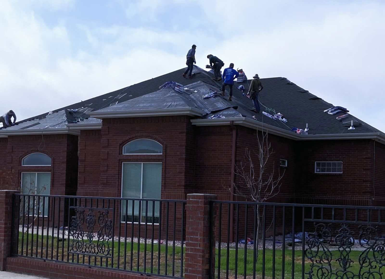 A G&M crew putting a new shingle roof on a brick house