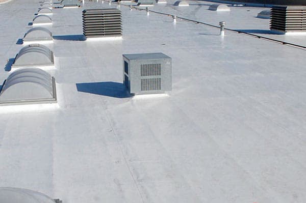 A white flat roof with skylights and an AC unit, from a G&M job.